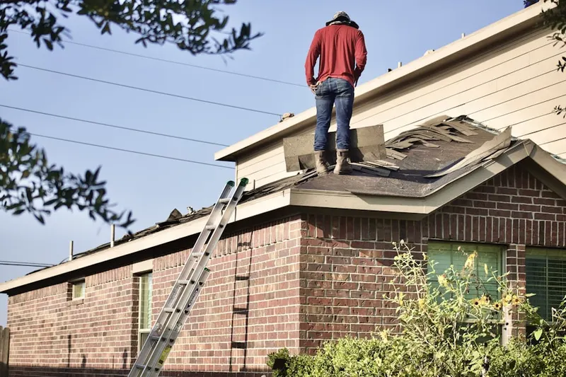 Professional roofer working on a residential roof in Greenwood Manor